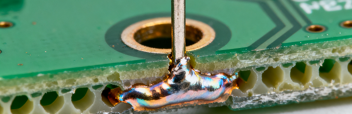 Cross-section of THT lead through PCB hole (soldered backside) showing robust bond
