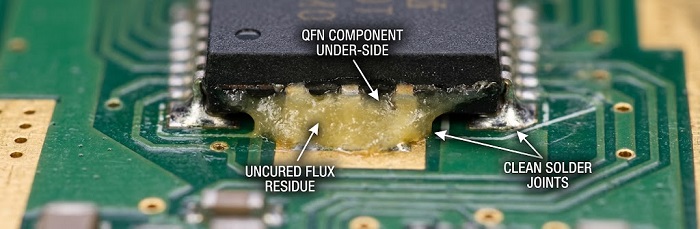 Close-up of uncured no-clean flux residue under a QFN component